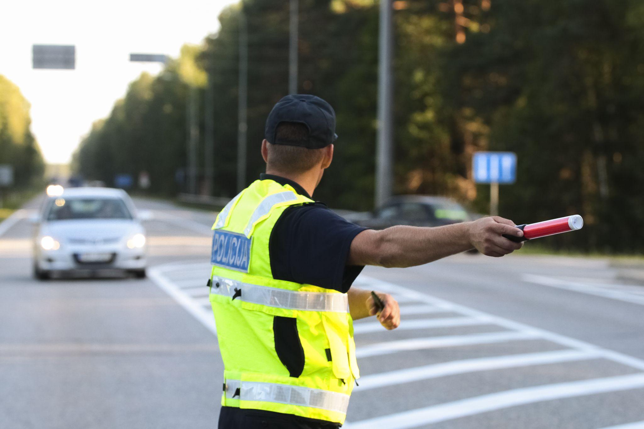 Certified traffic controller in reflective vest directing vehicles on a busy road, ensuring job site safety and smooth traffic flow for Maintenance Man Unlimited