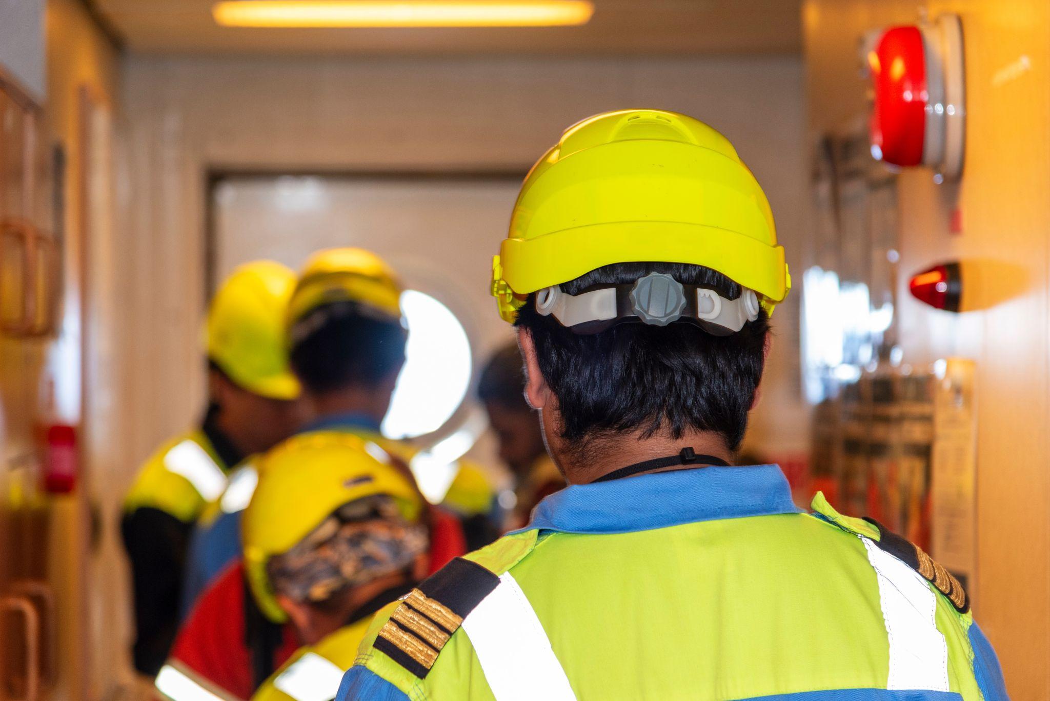 Crew members in safety gear coordinating inside a worksite hallway, symbolizing Maintenance Man Unlimited’s ability to mobilize last-minute labor quickly and efficiently.