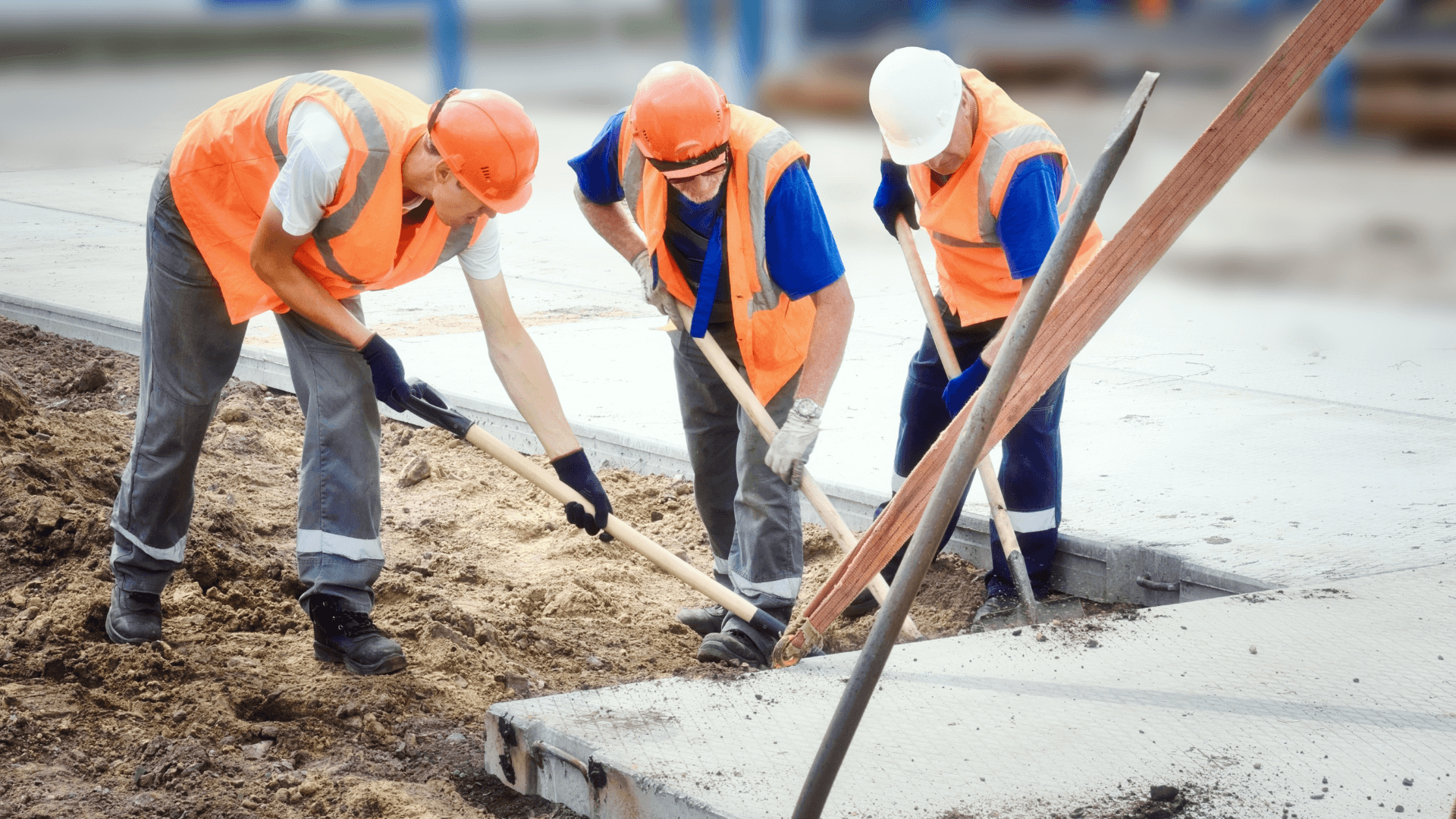 A group of construction workers lifting up a slab