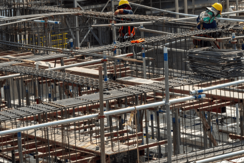 A group of construction workers putting up a metal block