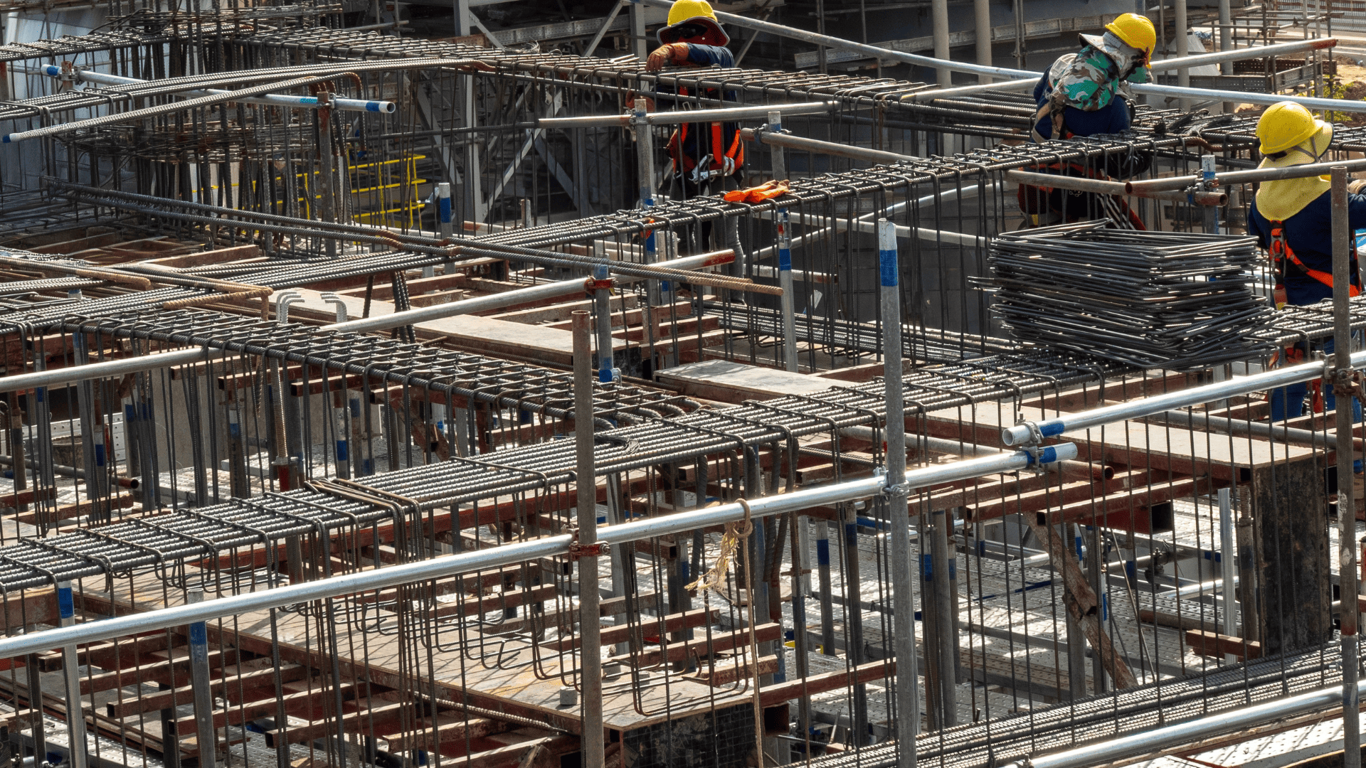 A group of construction workers putting up a metal block