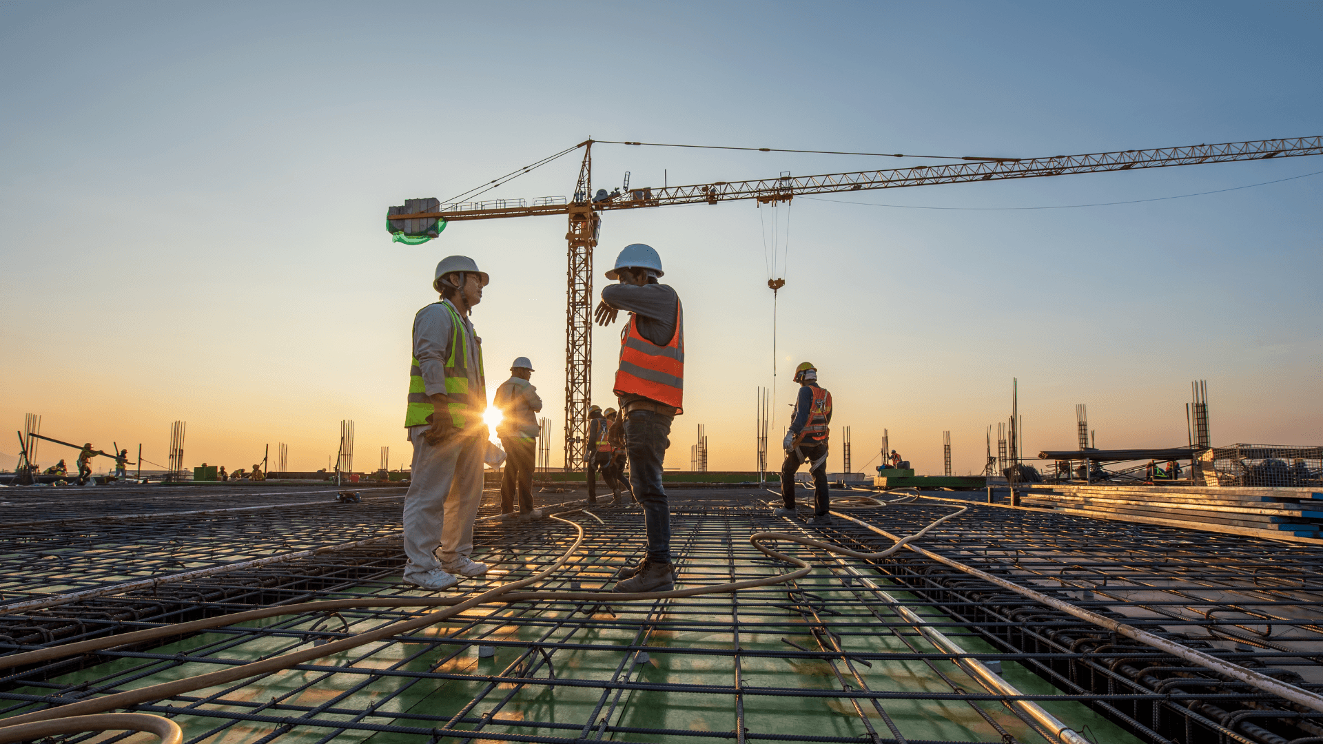 A group of construction workers stood on top of a metal base