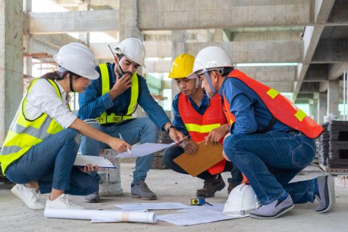 Construction team reviewing project plans together on a jobsite