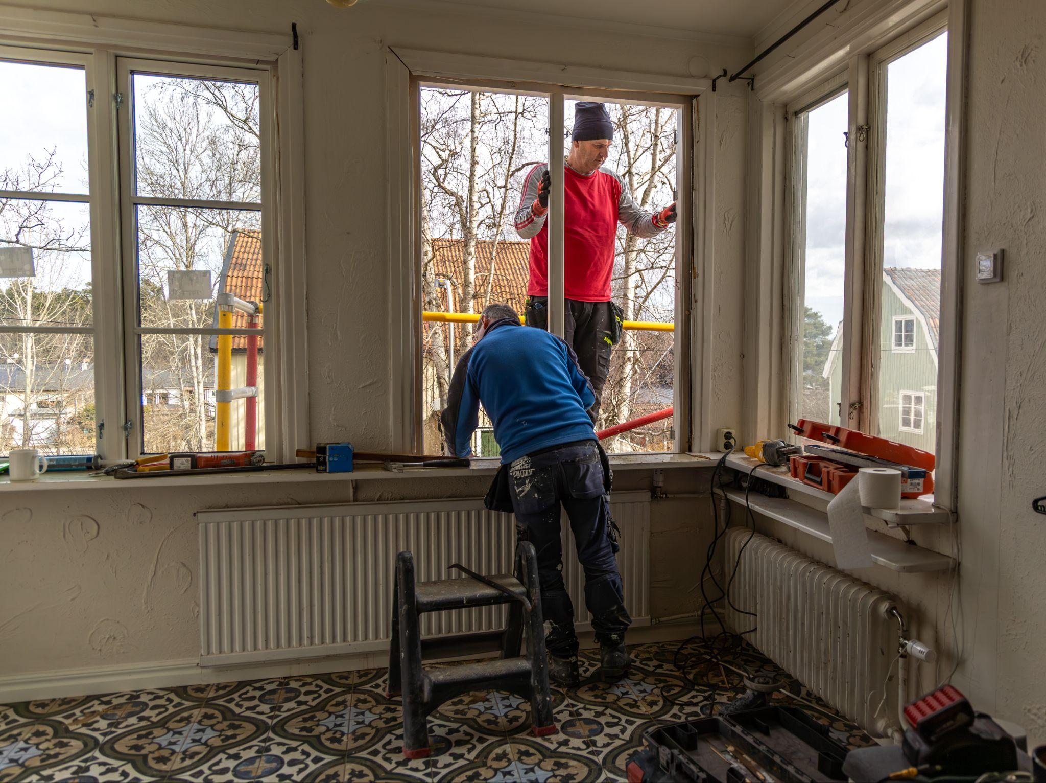 Maintenance crew repairing a window frame at a commercial property
